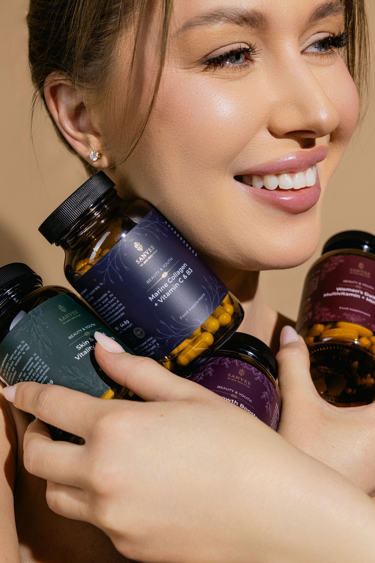 Close-up of woman holding multiple Sanvee supplements including marine collagen and skin and hair vitamins